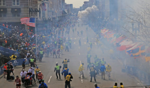 Rescue workers remove a woman injured in an explosion in Boston, near Monday