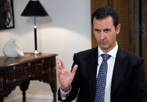 In this photo released by the Syrian official news agency SANA, shows Syrian President Bashar Assad, speaks during an interview with the Spanish news agency EFE, in Damascus, Syria, Friday, Dec. 11, 2015. Assad said in the interview that Saudi Arabia, the United States and some Western countries want "terrorist groups" to join peace negotiations to try end Syria's civil war. The Syrian government refers to all insurgent groups as terrorists. (SANA via AP)